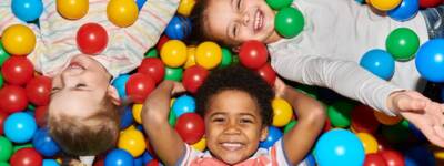Three Happy Kids Playing in Ballpit